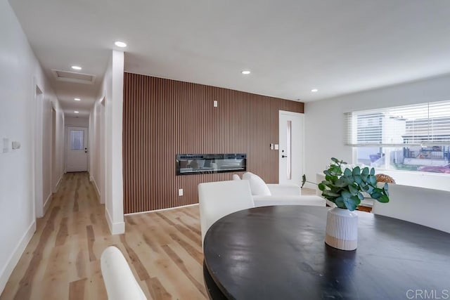 dining area with wood walls and light hardwood / wood-style floors