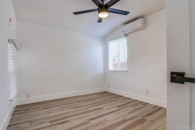 empty room featuring ceiling fan, light wood-type flooring, a wall mounted AC, and vaulted ceiling