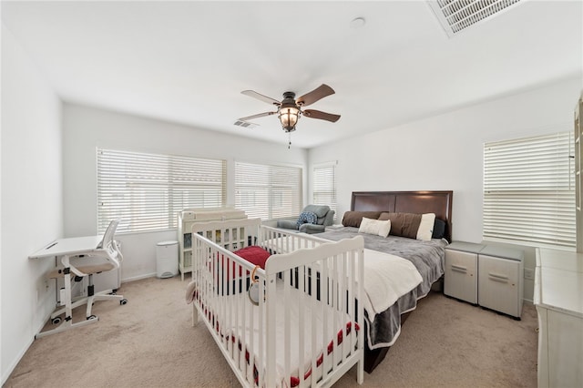 carpeted bedroom featuring multiple windows and ceiling fan