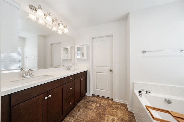 bathroom featuring tiled tub and vanity