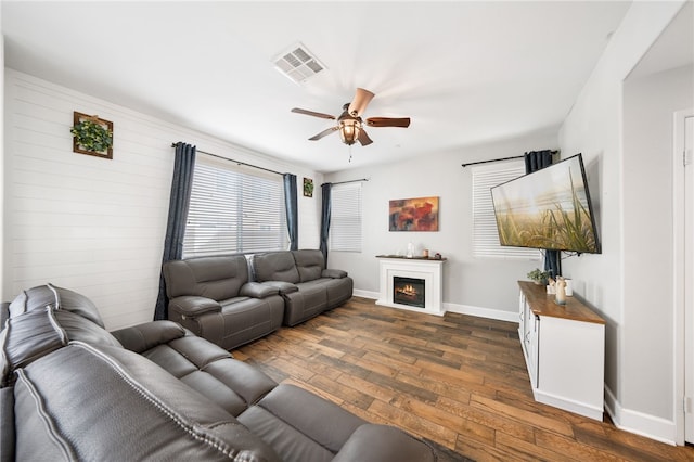 living room featuring ceiling fan and dark hardwood / wood-style flooring