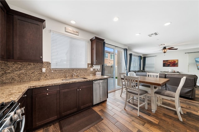 kitchen with light stone counters, dark hardwood / wood-style flooring, backsplash, and stainless steel appliances