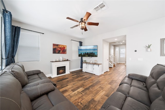 living room featuring ceiling fan and dark wood-type flooring