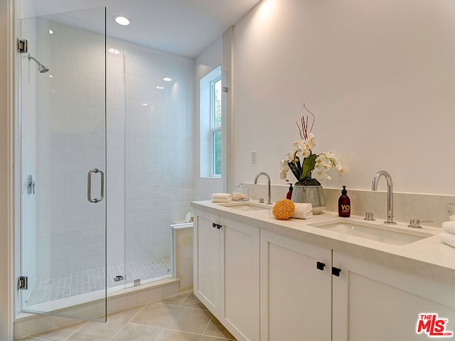 bathroom with a shower with door, tile patterned floors, and vanity