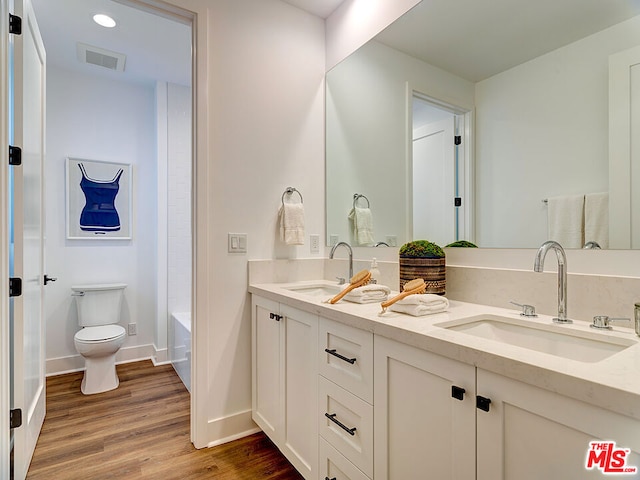 bathroom with wood-type flooring, toilet, and vanity