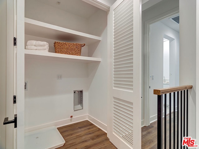 clothes washing area with dark wood-type flooring and hookup for a gas dryer