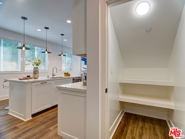 kitchen featuring dishwasher, white cabinetry, hanging light fixtures, sink, and dark wood-type flooring