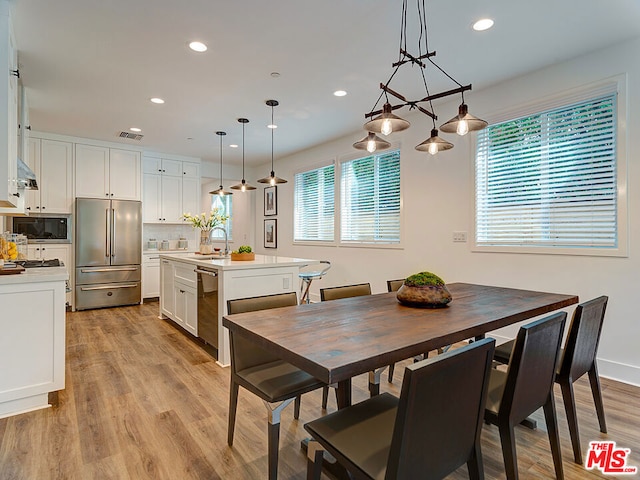 dining room featuring sink, a wealth of natural light, and light hardwood / wood-style floors