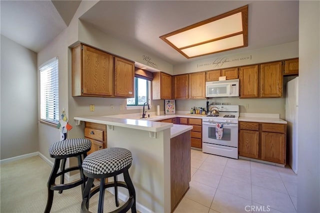 6279 Twinberry Cir Unit 7, Avila Beach, CA 93424 - kitchen with white appliances, brown cabinets, a peninsula, and a breakfast bar
