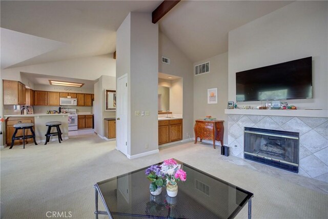 6279 Twinberry Cir Unit 7, Avila Beach, CA 93424 - living area with light colored carpet, beam ceiling, a tiled fireplace, and high vaulted ceiling