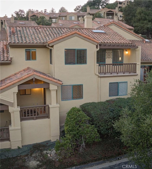 6279 Twinberry Cir Unit 7, Avila Beach, CA 93424 - view of front of home with a balcony, stucco siding, a tile roof, and a chimney