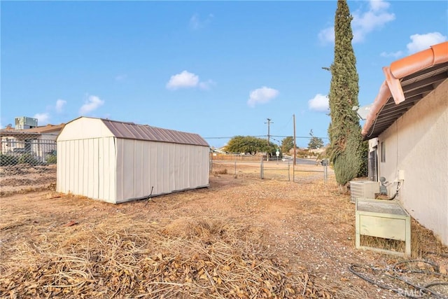 view of yard with a shed, fence, and an outdoor structure