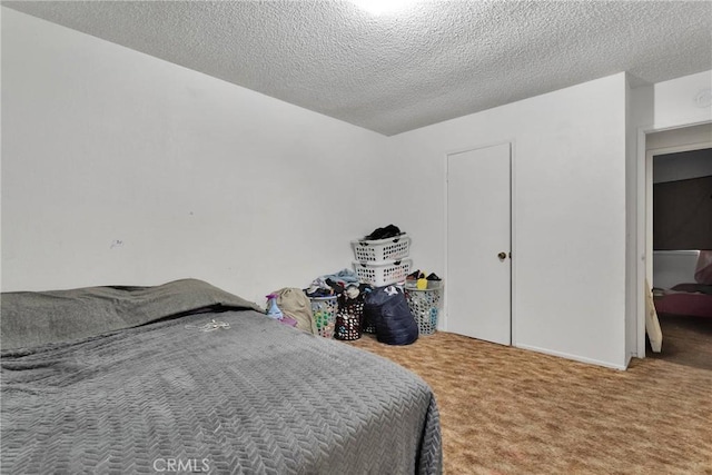 bedroom featuring a textured ceiling and carpet floors