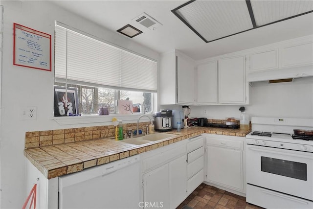 kitchen with white appliances, visible vents, white cabinets, and a sink