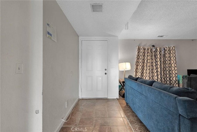 living room with visible vents, a textured ceiling, and tile patterned floors