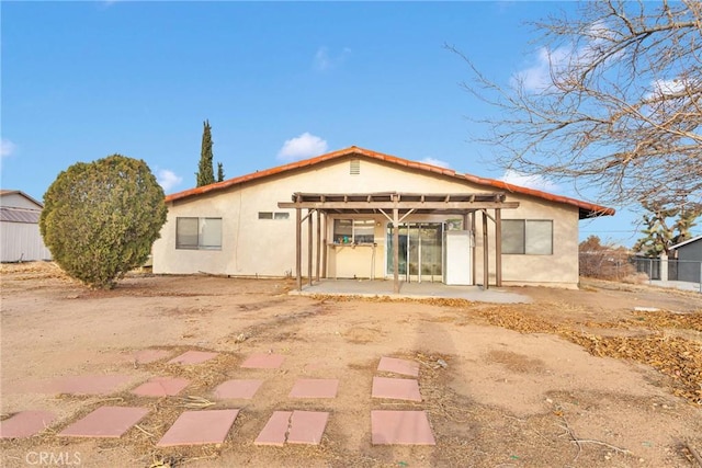 rear view of property with a pergola, a patio, and stucco siding