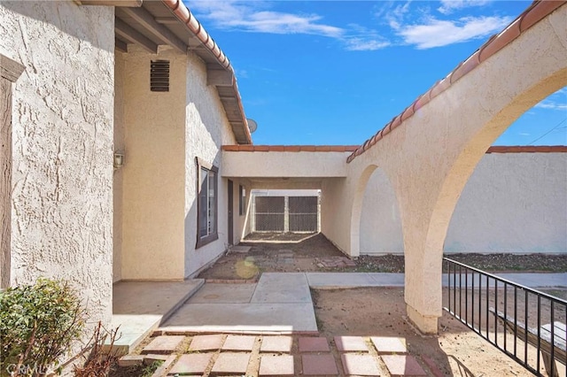 doorway to property featuring a patio area and stucco siding