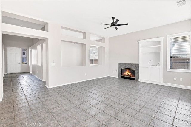 unfurnished living room with ceiling fan, built in features, and tile patterned flooring