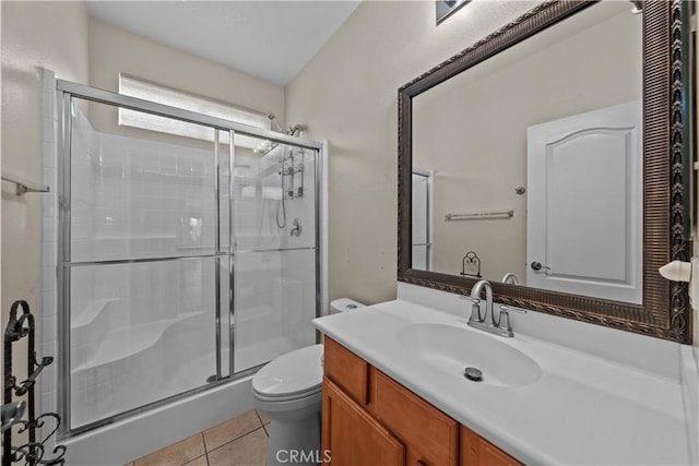 bathroom with tile patterned flooring, vanity, toilet, and walk in shower