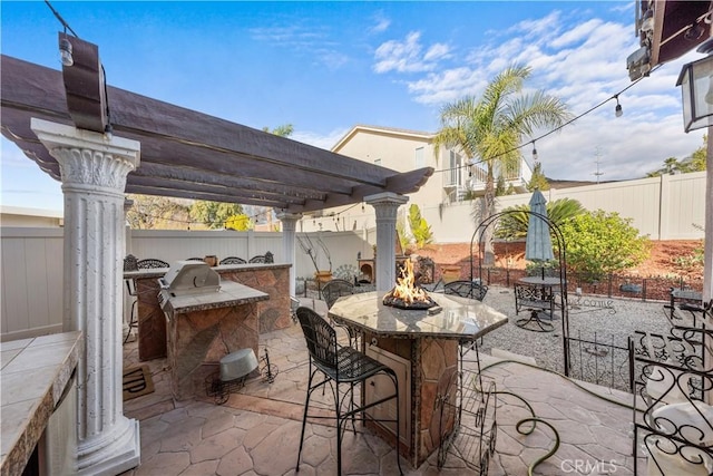 view of patio featuring an outdoor kitchen, a pergola, an outdoor fire pit, and a bar