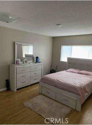 bedroom with light hardwood / wood-style flooring and a textured ceiling