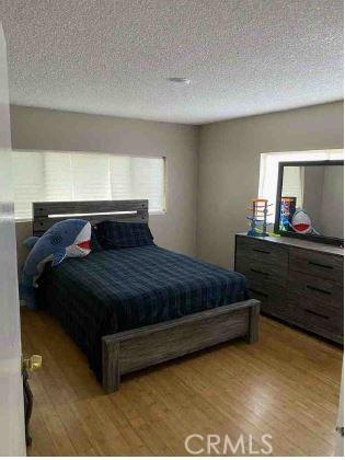 bedroom featuring wood-type flooring and a textured ceiling