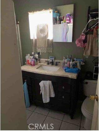 bathroom featuring vanity, toilet, and tile patterned flooring