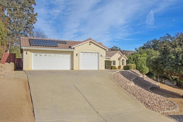 view of front of property with a garage and solar panels