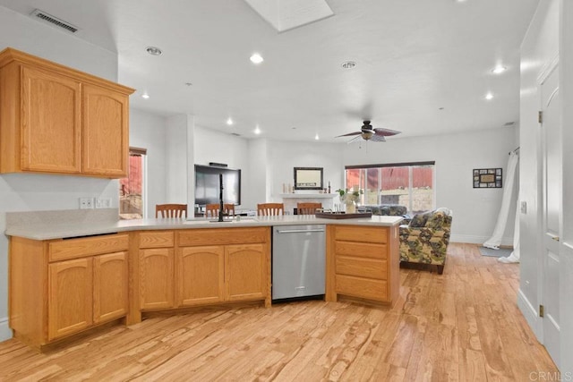 kitchen featuring stainless steel dishwasher, sink, light hardwood / wood-style flooring, kitchen peninsula, and ceiling fan