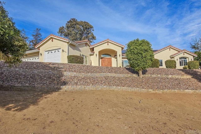 mediterranean / spanish-style house with a garage