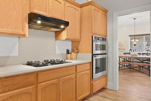 kitchen with double oven, an inviting chandelier, light hardwood / wood-style floors, decorative backsplash, and gas cooktop