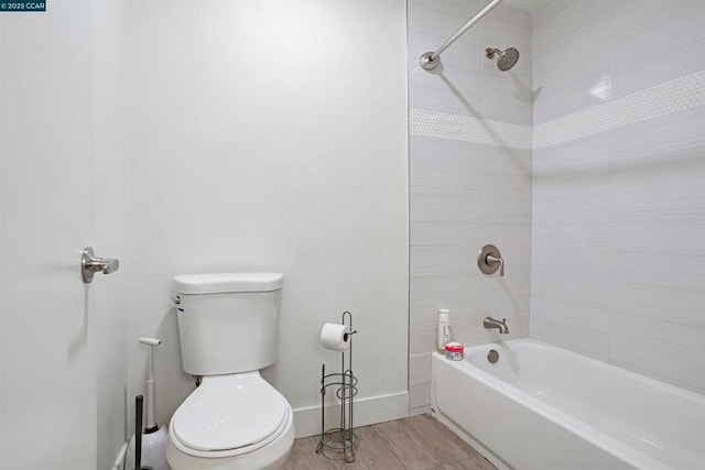 bathroom featuring wood-type flooring, toilet, and tiled shower / bath