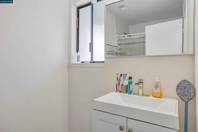 bathroom featuring a shower with shower curtain and vanity