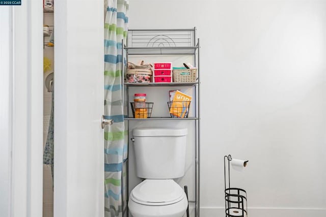 bathroom featuring curtained shower and toilet