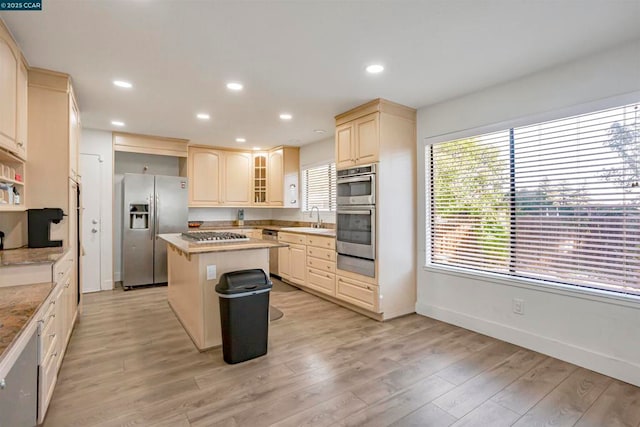 kitchen with sink, stainless steel appliances, a center island, and light hardwood / wood-style floors