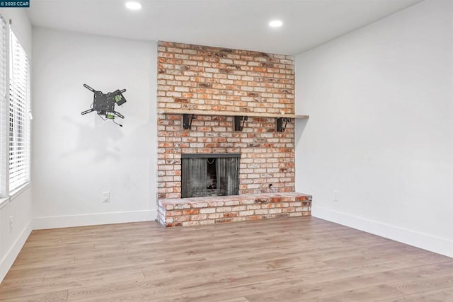 unfurnished living room featuring a fireplace and light wood-type flooring