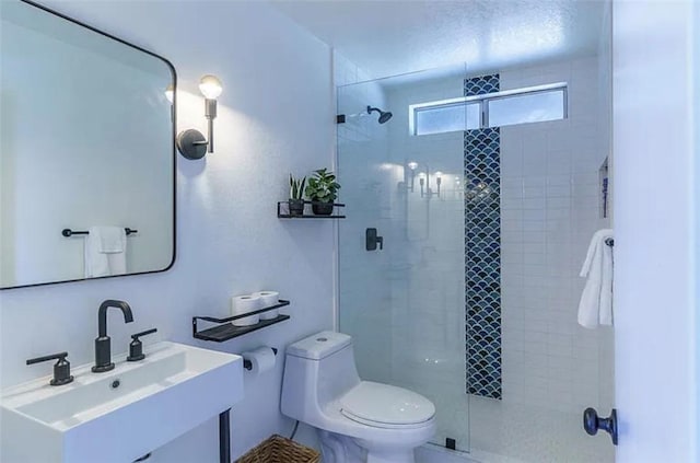 bathroom featuring toilet, a shower with door, and vanity