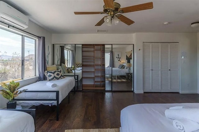 bedroom featuring ceiling fan, a wall mounted AC, and dark wood-type flooring