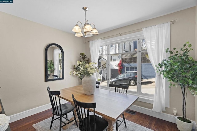 dining area with dark hardwood / wood-style floors and a notable chandelier