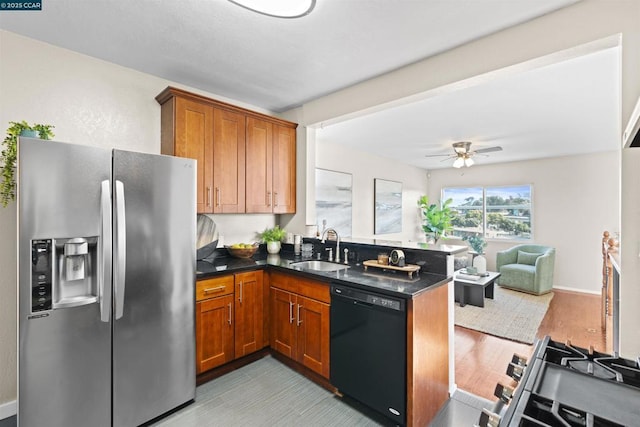 kitchen with black dishwasher, sink, kitchen peninsula, ceiling fan, and stainless steel fridge