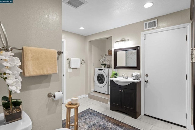 bathroom with tile patterned floors, vanity, and washer / clothes dryer