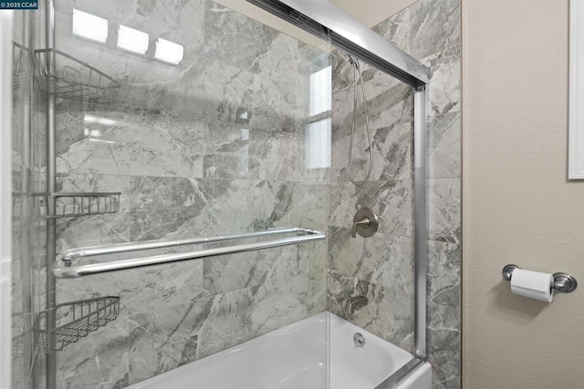 bathroom featuring bath / shower combo with glass door