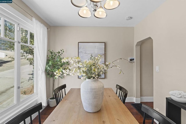 dining space with an inviting chandelier and dark hardwood / wood-style flooring