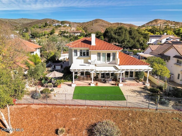 rear view of property featuring a balcony, a yard, a patio area, and a pergola