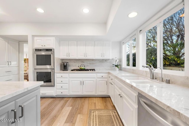 kitchen featuring white cabinetry, appliances with stainless steel finishes, sink, and tasteful backsplash