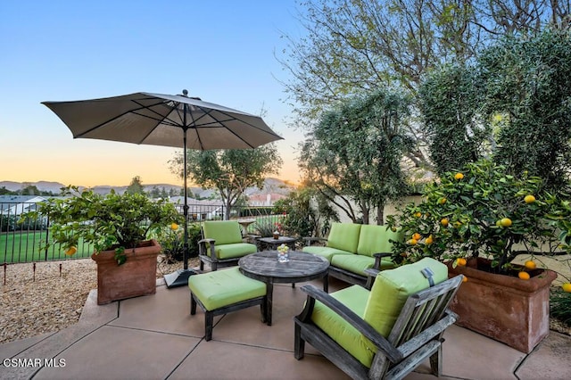 patio terrace at dusk featuring an outdoor living space