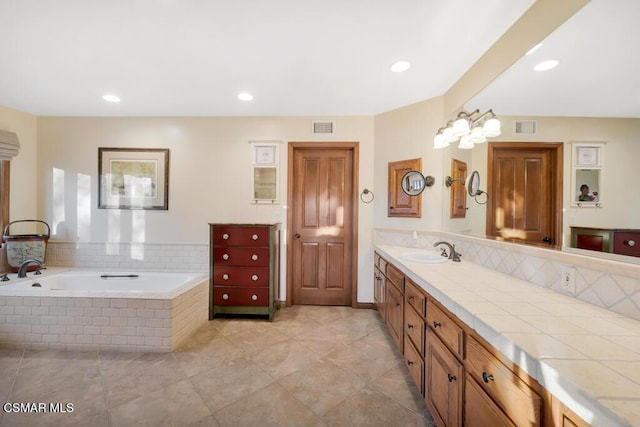 bathroom featuring vanity and tiled bath