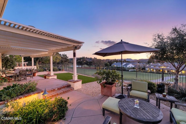 patio terrace at dusk featuring a pergola