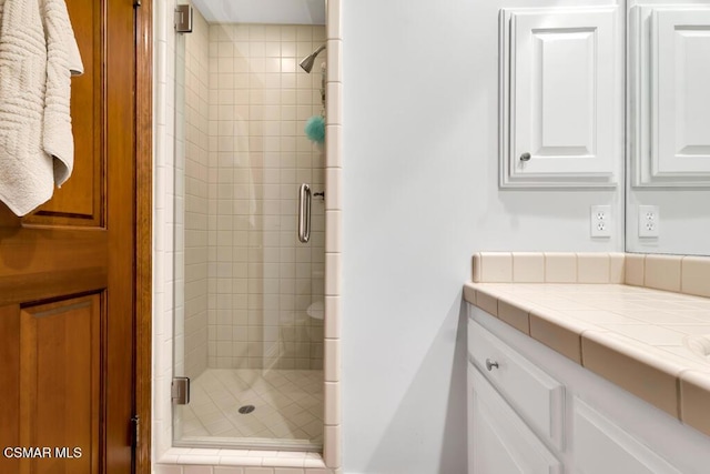 bathroom featuring vanity and a shower with shower door