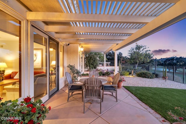 patio terrace at dusk with a pergola and a lawn